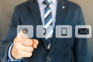 man pointing at icons for email, phone, website and address