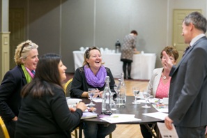 some women and a man having a conversation around a circular table