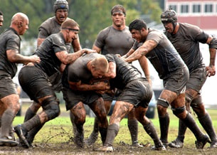 men playing rugby in the mud