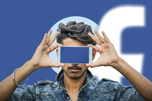 man holding a smartphone in front of his eyes with a blank, blue screen